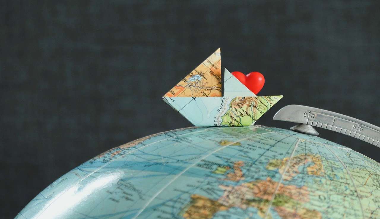 barca di carta su globo a tema geografico