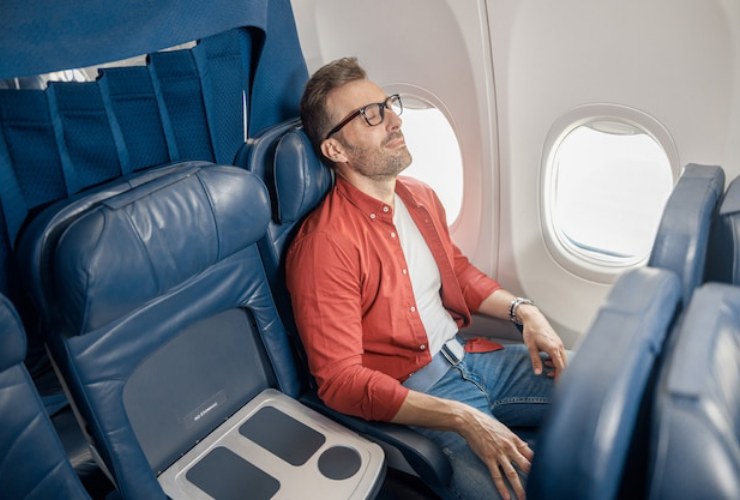 Uomo che dorme in aereo