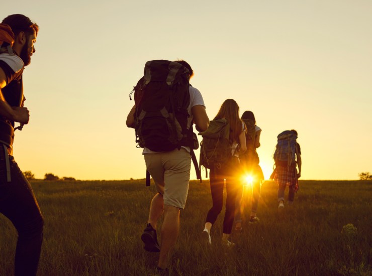 Illustrazione di alcune persone mentre fanno trekking (Canva FOTO) - cosediviaggio.it